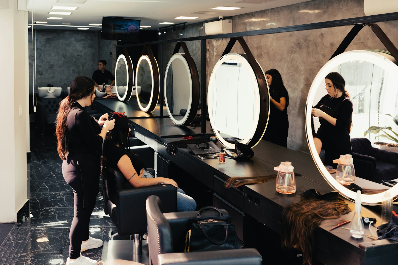 Profissional finalizando cabelo de uma cliente em salão de beleza